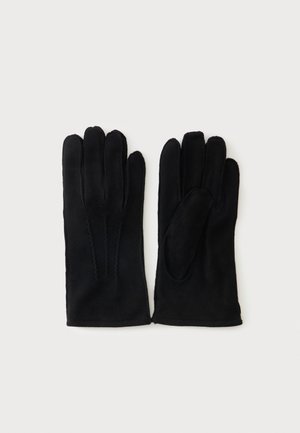 Een paar zwarte suède handschoenen met decoratieve stiksels op de achterkant, plat gelegd met palm en achterkant zichtbaar op een witte achtergrond.