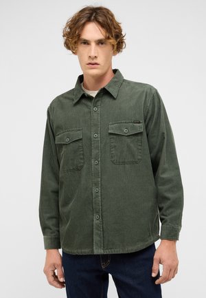 Green corduroy shirt with a collar, long sleeves, two front pockets, and button closure. Features vertical ribbed texture.