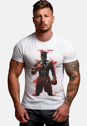 White t-shirt featuring a graphic of a boxer in red shorts, with red splatter accents. The boxer is shown wearing red gloves and standing confidently.