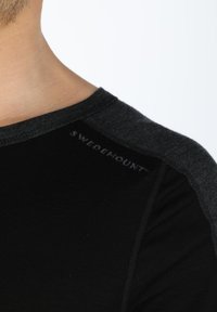 Black t-shirt with gray shoulder accents, featuring a round neckline and the text "SWEDEMOUNT" embroidered on the shoulder. Soft texture.
