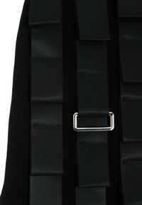 Tejido negro con cintas de satén en capas, que presenta un hebilla de metal plateado como detalle notable. La textura es suave y lisa.