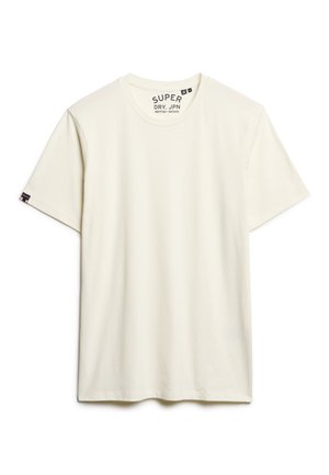 T-shirt en coton couleur crème avec des manches courtes, encolure ras du cou et une étiquette cousue sur la manche gauche. Texture lisse, design simple.