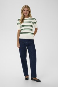 Pruhovaný pletený svetr v krémové barvě se zelenými pruhy, krátké rukávy, kulatý výstřih; spárován s tmavě modrými širokými džíny a černými balerínkami.
