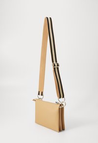 Tan leather handbag with a zip closure, featuring a thick, striped adjustable strap in black and tan. Rectangular shape with a smooth texture.