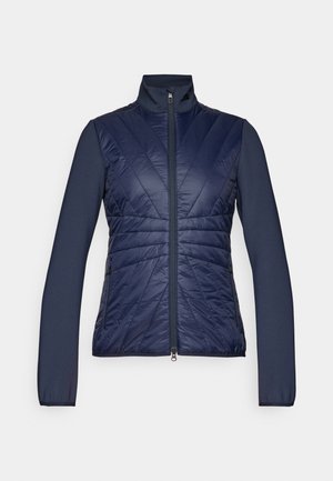 Marineblauwe jas met gequiltte voorkant, effen mouwen en hoge kraag. Voorzien van een centrale rits, textuurpatroon en slim fit ontwerp.