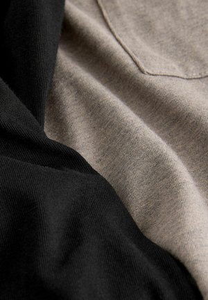 Dva kusy tkaniny, jedna čierna a jedna béžová, ležia vedľa seba. Obe majú hladký povrch s jemnými, tesne tkanými vzormi.