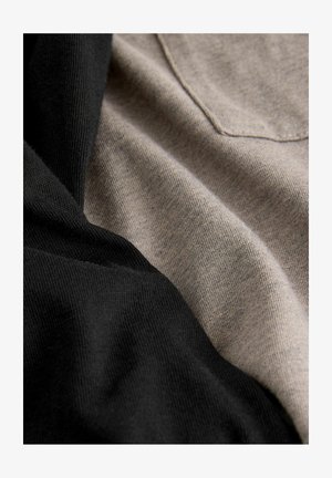 Két darab anyag, az egyik fekete, a másik bézs, egymás mellett fekszik. Mindkettő sima textúrával rendelkezik, finom, szorosan szőtt mintákkal.