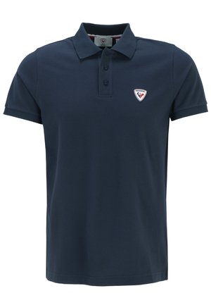 Polo de color azul marino hecho de algodón. Cuenta con un collar, tapeta de tres botones y un pequeño logo bordado en el lado izquierdo del pecho.