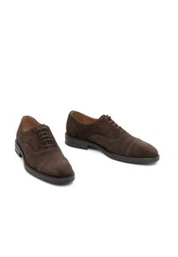 Braune Wildleder-Herrenschuhe mit abgerundeter Spitze, klassischer Schnürung und strukturierter Oberfläche. Verfügen über eine kontrastierende dunkle Sohle.