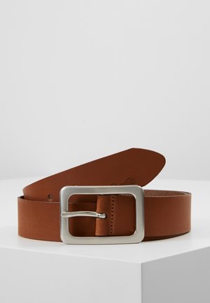 Ceinture en cuir marron avec une boucle métallique rectangulaire argentée, posée enroulée sur une surface blanche sur un fond uni.