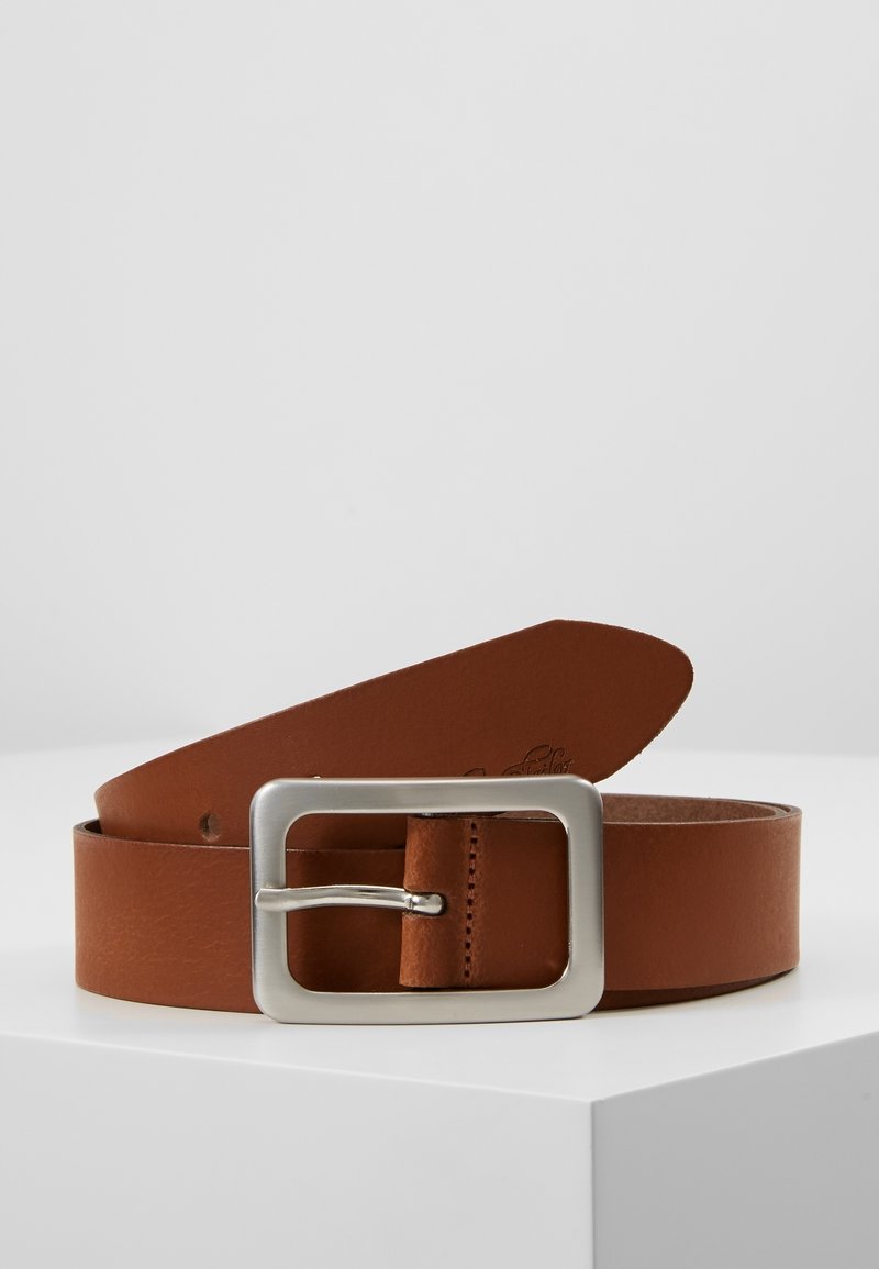 Ceinture en cuir marron avec une boucle métallique rectangulaire argentée, posée enroulée sur une surface blanche sur un fond uni.