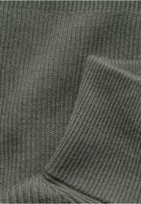 Mörkgrön stickad tyg med ribbad textur, med en vikta kant och en mjuk, slät yta. Idealisk för kläddesign.