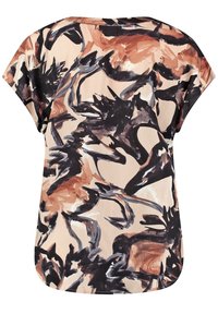 Blouse à manches courtes avec motif abstrait de coups de pinceau en noir, marron et tons beiges sur un fond clair.