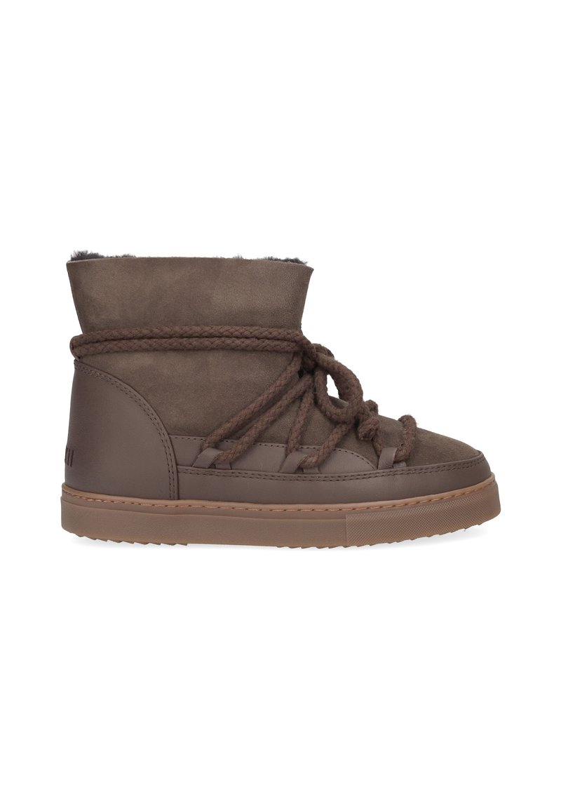 Bottines marron mi-hautes en suède avec une finition texturée. Comprend un col rembourré, des lacets superposés et une semelle en caoutchouc.