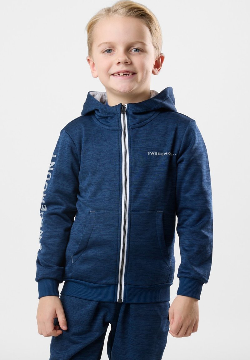 Marinblå zip-up hoodie i ett texturerat tyg med huva, med framfickor och vit logotyp på bröstet och ärmen.