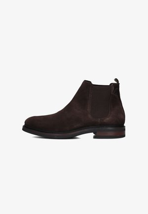 Bottines en suède marron avec des panneaux latéraux élastiques, bout arrondi et une petite languette, présentant une semelle contrastante marron foncé.
