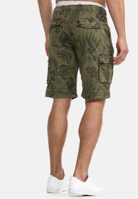 Cargo shorts i grönt med svart blommönster, med flera sidofickor, en avslappnad passform och en upprullad fåll.