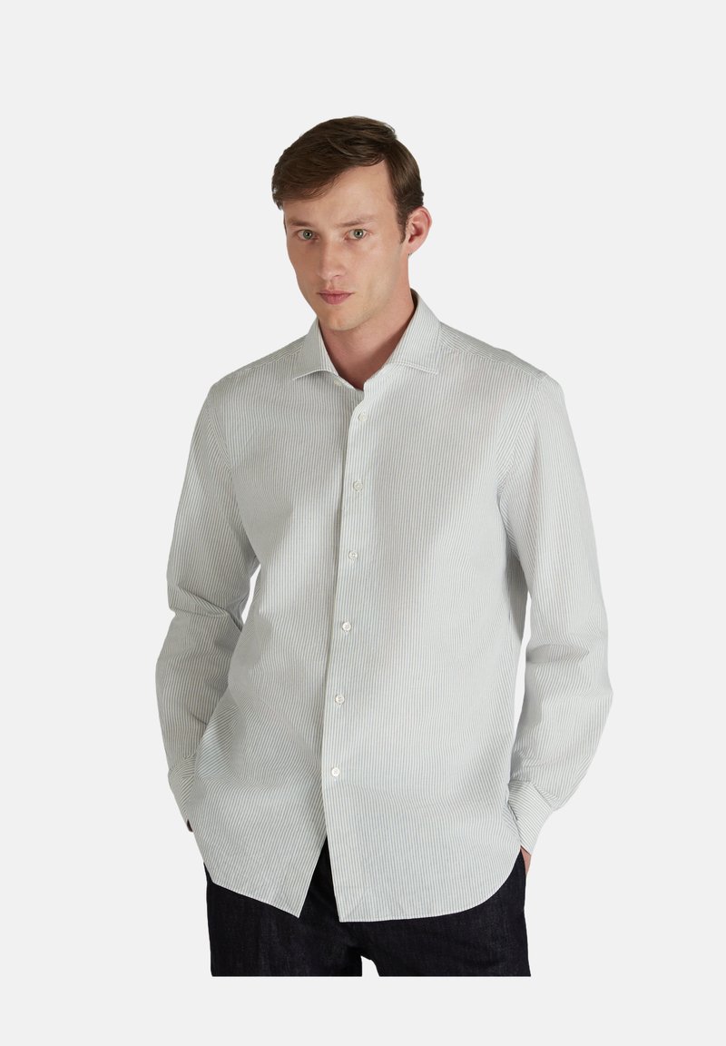 Camicia bianca con righe verticali azzurro chiaro, colletto button-down, maniche lunghe e orlo curvo. Realizzata in un tessuto liscio.
