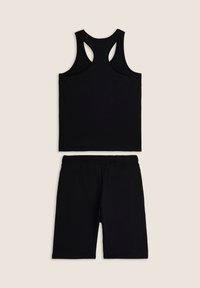 Top negro sin mangas con diseño de racerback y pantalones cortos a juego de longitud hasta la rodilla. Ambos fabricados con una tela suave, con una banda elástica en los pantalones cortos.