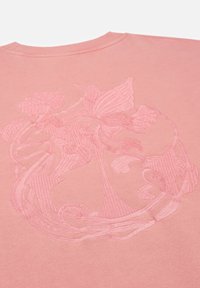 Roze sweatshirt met gestructureerde borduursels van bloemen- en vlinderontwerpen. Zachte stof met een ribbelkraag, die de gedetailleerde patronen benadrukt.