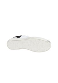 Sneaker bianco con suola in gomma testurizzata, caratterizzato da un accento nero vicino al tallone e materiale superiore liscio. Design della punta piatta e arrotondata.