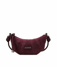 Bolso de bolso de ante burdeos oscuro con forma curvada, correa de cuero anudada, herrajes de plata y etiqueta de marca. Textura suave con detalles de costura.