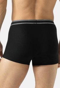 Boxer aderenti neri con texture a coste, vita elastica con accenti grigi e una vestibilità aderente per comfort e supporto.