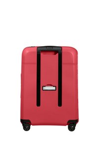 Hard-shell suitcase in bright pink, featuring a textured surface, black retractable handle, and four wheels for mobility.