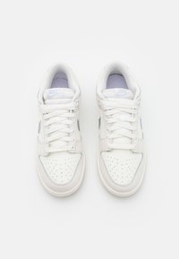 Pair of white Nike sneakers with light gray swoosh logos and perforations on the toe box, shown from a top-down view on a white background.