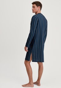 Robe lungo a maniche lunghe di color blu navy con righe verticali, caratterizzato da spacchi laterali, una texture di tessuto morbido e un design minimalista.
