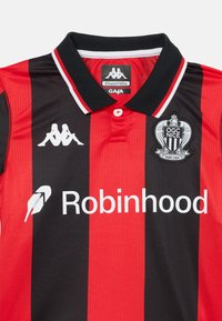Jersey a rayas rojas y negras con cuello, que lleva un logo de Kappa, una insignia del OGC Nice y el nombre "Robinhood" en blanco.