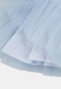 Jasnoniebieska, warstwowa tkanina z tiulu na gładkim materiale bawełnianym, prezentująca delikatne, przezroczyste tekstury i miękkie fałdy.