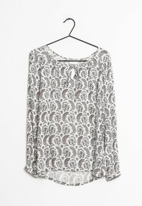 Langärmlige Bluse mit Rundhalsausschnitt und Schlüssellochdetail. Weißer Stoff mit schwarzem und rotem Paisleymuster. Leicht und in fließendem Design.