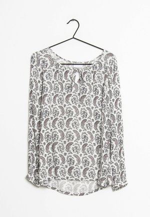 Langarmblouse met een ronde hals en uitsnijding. Witte stof met een zwart en rood paisley patroon. Lichtgewicht en draperende uitstraling.