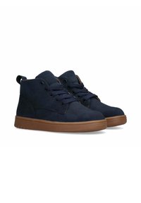 Scarpe alte in suede blu navy con suole in gomma marrone, punta tonda, occhielli metallici e lacci blu navy. Piccola linguetta sul retro.