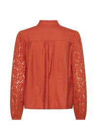 Blouse orange avec un corps en tissu uni et des manches en dentelle, dotée d'un col à volants et d'un dos froncé, conçue pour une coupe ample.