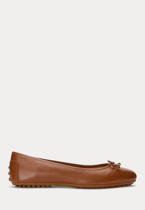 Ballerine en cuir marron avec bout arrondi, petit nœud décoratif à l'avant, et clous en caoutchouc sur la semelle et le talon.