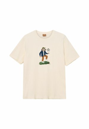 Kremfarvet T-shirt med en tegneseriehund, der har en grøn kasket, en blå jakke og brune bukser på og leger med en sort-hvid fodbold.