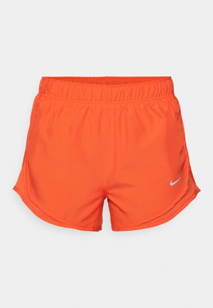 Shorts de sport orange en matériau léger, dotés d'une taille élastique et d'un petit logo réfléchissant Nike sur le côté inférieur gauche.