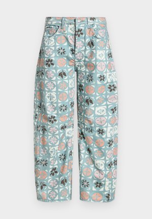 Pantalon large bleu clair avec motifs floraux et géométriques rose, blanc et brun, bouton sur le devant et poches.