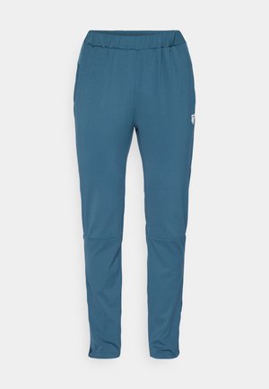 Sinised spordipüksid elastse vöökoha, kitsenevate jalgade ja lukuga pahkluudega. Valmistatud siledast ja kergest kangast.