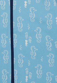 Tessuto azzurro chiaro con un motivo ripetuto di cavallucci marini bianchi e bolle, con una cerniera blu navy lungo un lato.