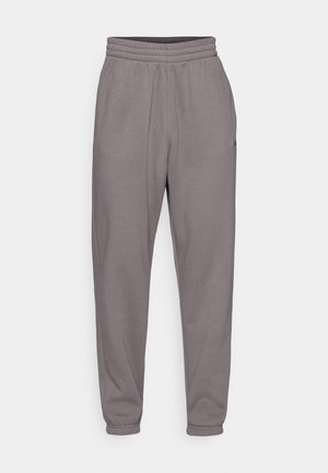 Pantalon jogger gris avec taille élastique, coupe fuselée et poignets élastiques, présenté sur un fond uni.