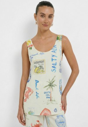 Frau trägt ärmelloses Oberteil und Hose mit bunten Strandmotiven, darunter Palme, Krabbe, Zitrone und Sprüche wie "Salty Air" und "Beach life."