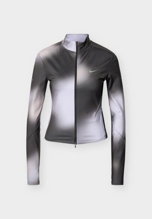 Γυναικείο αθλητικό μπουφάν σε γκρί διαβάθμιση και λευκό, με ψηλό γιακά, μακριά μανίκια, κλείσιμο με φερμουάρ και αντανάκλαστη λεπτομέρεια με λογότυπο.