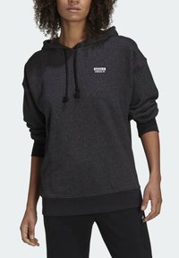 Ciemnoszara bluza z kapturem wykonana z miękkiego materiału, wyposażona w przednią kieszeń, kaptur ze sznurkiem oraz małe białe logo na piersi. Standardowy krój.