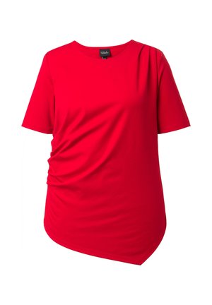 Punainen naisten lyhythihainen paita epäsymmetrisellä helmalla, lievästi ryppyinen vasemmalla puolella, pyöreä pääntie ja pehmeä kangas.