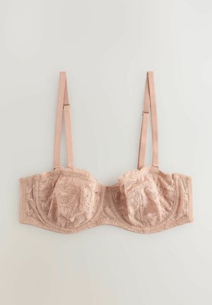 Lace underwire bra in soft peach with floral patterns, scalloped edges, adjustable straps, and a seamless band for support.