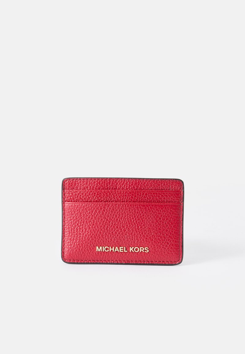 Red leather cardholder with textured finish, featuring four card slots and gold "MICHAEL KORS" logo embossed on the front.