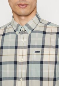 Geruite shirt in lichtblauw, crème en marineblauwe tinten; button-down kraag; borstzak; Barbour logo tag; zachte stof met een gladde textuur.